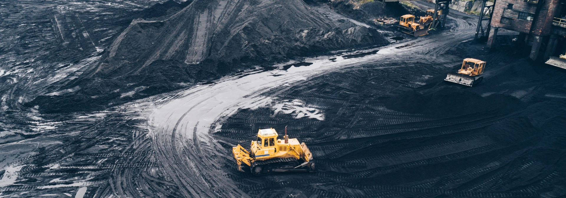 Bulldozers working across a mined material yard